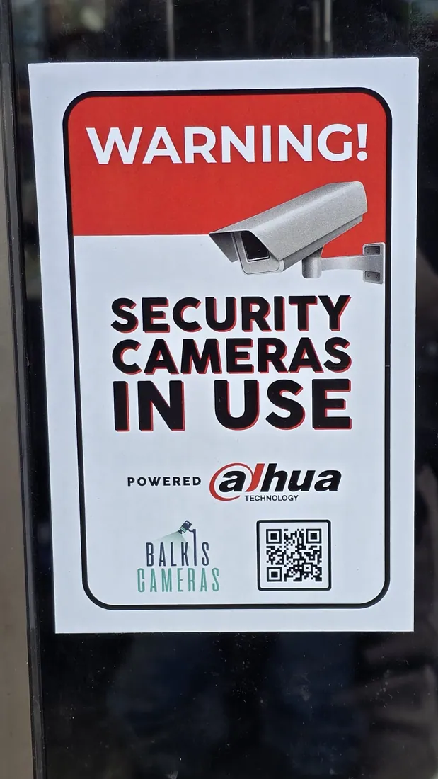 Balkis Cameras warning sign on a storefront door